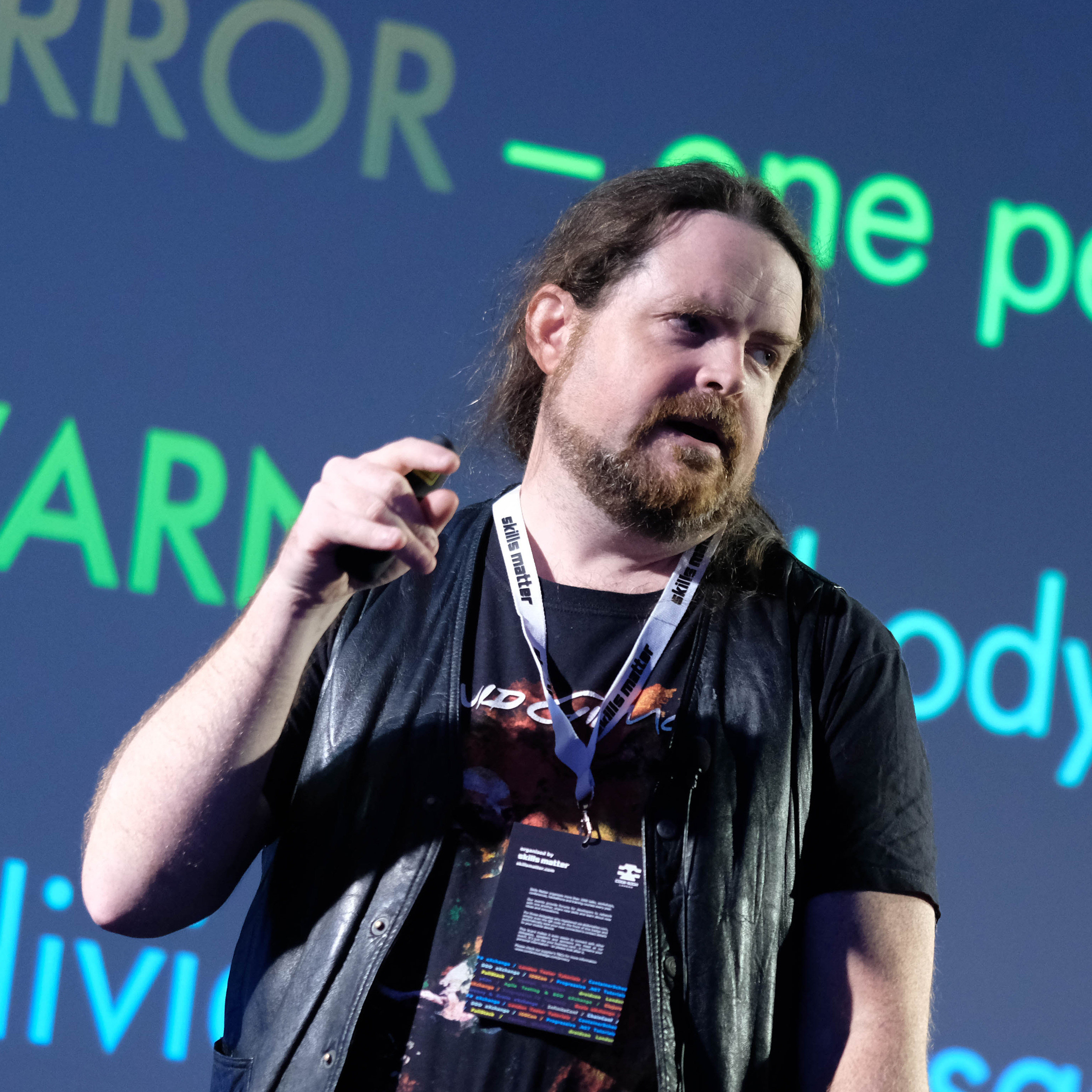 Photograph of Dylan Beattie speaking on stage at a technology conference